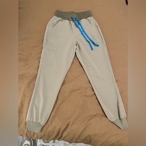 Figs brand, size XS petite, high waisted jogger scrub pants in tan.